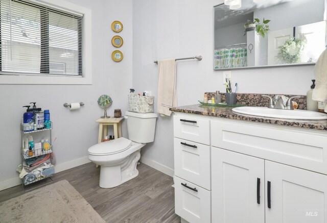 1713 Blaine St, Caldwell, ID 83605 - full bathroom with wood finished floors, baseboards, toilet, and vanity