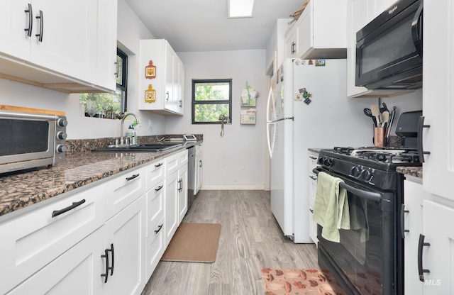 1713 Blaine St, Caldwell, ID 83605 - kitchen featuring black appliances, a sink, light wood-style floors, white cabinetry, and dark stone counters