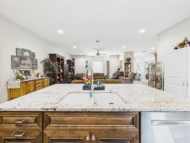 kitchen with a sink, dishwasher, open floor plan, an island with sink, and recessed lighting