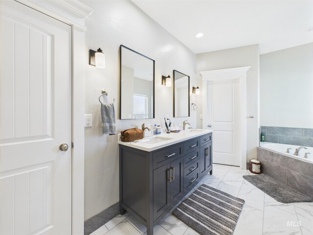 bathroom with a bath, double vanity, and marble finish flooring
