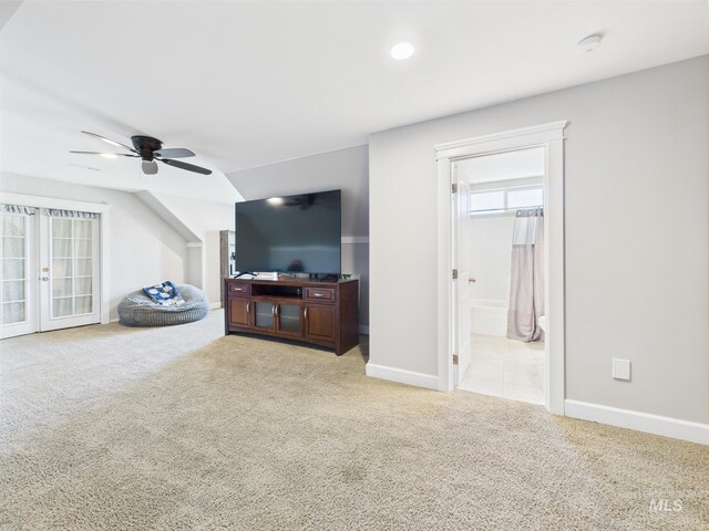 carpeted living room with ceiling fan, baseboards, and french doors