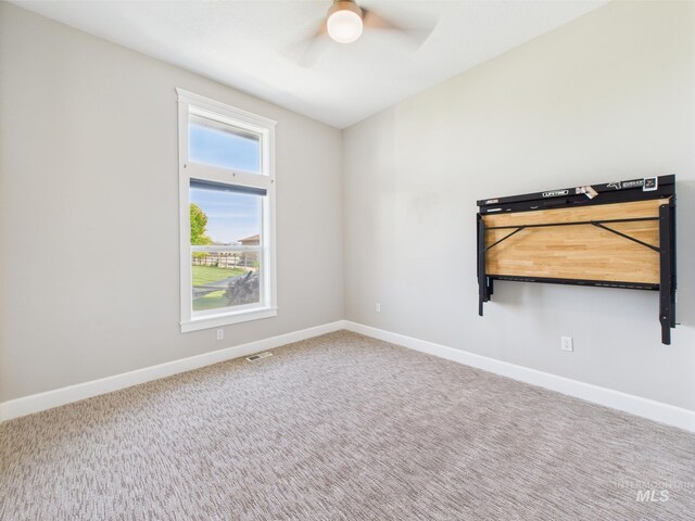 spare room featuring a ceiling fan, baseboards, and carpet flooring