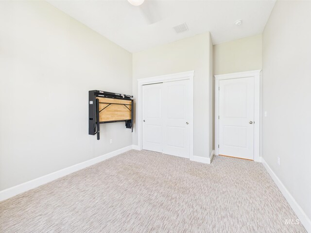 unfurnished bedroom featuring carpet flooring, baseboards, and a closet