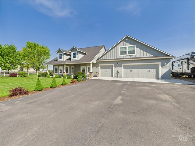 view of front of home with board and batten siding, a front yard, driveway, and an attached garage