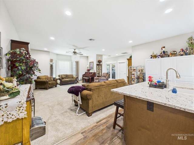 living area with light wood-style flooring, recessed lighting, and a ceiling fan