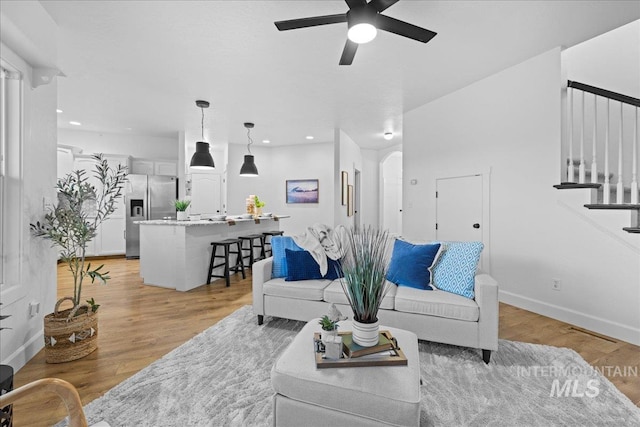 living room featuring ceiling fan and light hardwood / wood-style floors