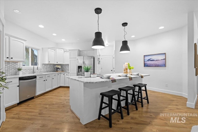 kitchen featuring white cabinetry, a center island, light hardwood / wood-style flooring, and appliances with stainless steel finishes