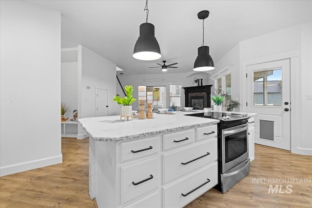 kitchen with white cabinets, electric range, a kitchen island, decorative light fixtures, and light hardwood / wood-style floors