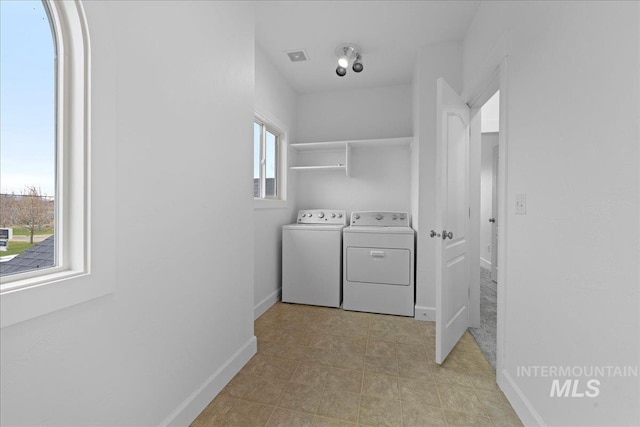 washroom with plenty of natural light and washer and dryer