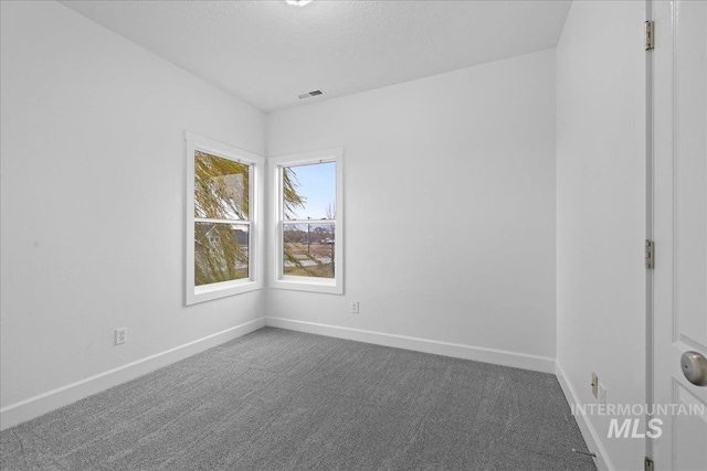 empty room featuring dark colored carpet