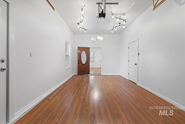 entryway with hardwood / wood-style flooring, a notable chandelier, and rail lighting