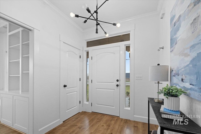 foyer with light hardwood / wood-style flooring, a chandelier, and ornamental molding