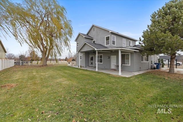 rear view of property with a lawn and a patio area