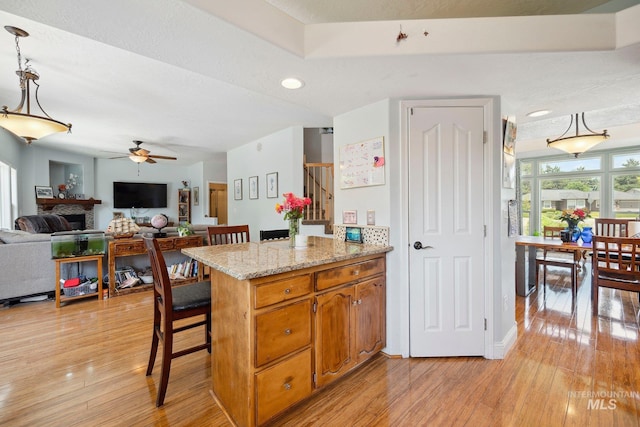 1229 N Hiltonhead Way, Eagle, ID 83616 - kitchen with ceiling fan, a peninsula, light wood-style flooring, open floor plan, and recessed lighting