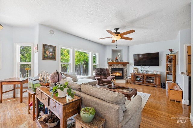 1229 N Hiltonhead Way, Eagle, ID 83616 - living room featuring plenty of natural light, light wood-style flooring, a ceiling fan, and a textured ceiling