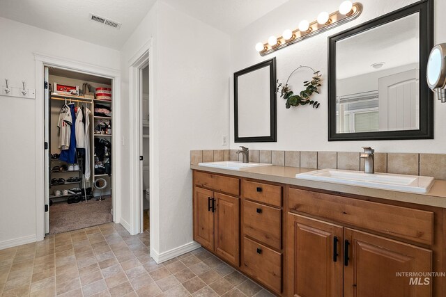 4902 N Schubert Ave, Meridian, ID 83646 - full bathroom with double vanity, toilet, a spacious closet, and baseboards