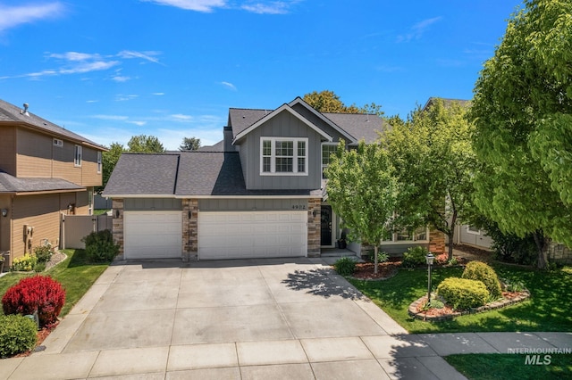 4902 N Schubert Ave, Meridian, ID 83646 - view of front of house with board and batten siding, driveway, a garage, stone siding, and a front yard