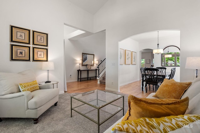 4902 N Schubert Ave, Meridian, ID 83646 - living area with arched walkways, a towering ceiling, stairs, baseboards, and wood finished floors