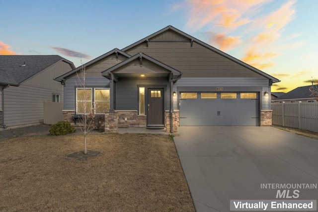 craftsman inspired home with stone siding, driveway, a garage, and fence