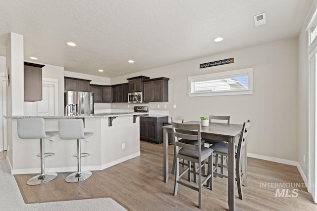dining room featuring recessed lighting, visible vents, light wood-type flooring, and baseboards