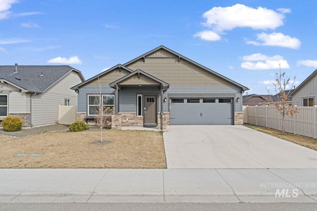 craftsman-style home featuring stone siding, an attached garage, concrete driveway, and fence