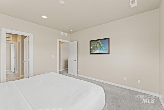 bedroom featuring visible vents, light carpet, and baseboards
