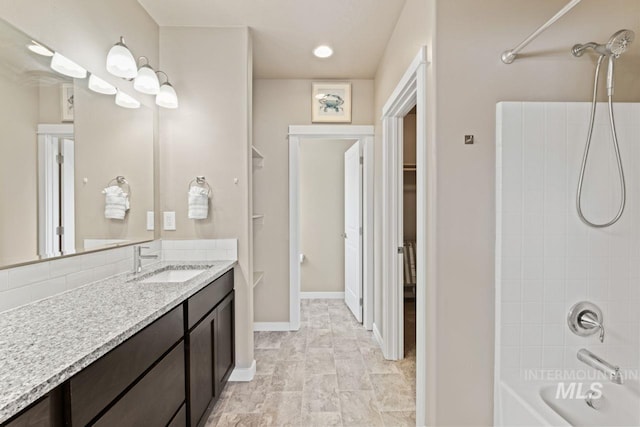 full bath with vanity, shower / bathing tub combination, and baseboards