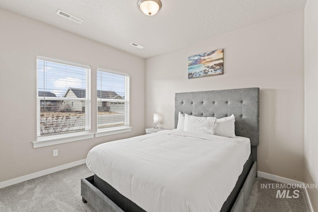 bedroom featuring visible vents, baseboards, and carpet