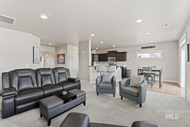 living room with recessed lighting, baseboards, and visible vents
