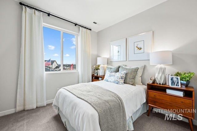 carpeted bedroom featuring baseboards and visible vents