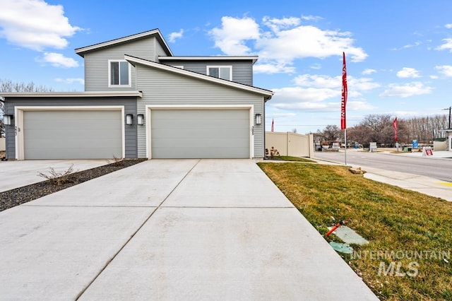 view of front of home featuring an attached garage, driveway, and fence