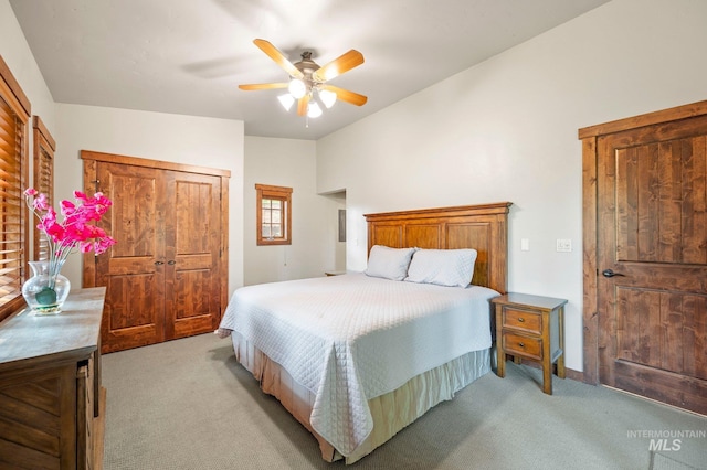 carpeted bedroom with ceiling fan and a closet