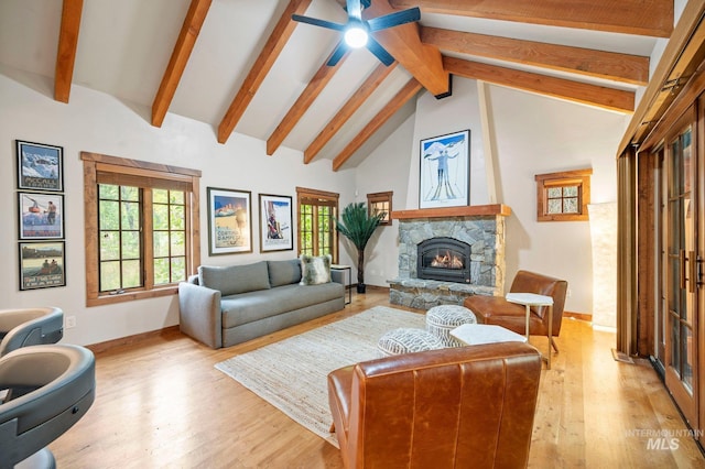 living room featuring ceiling fan, beam ceiling, high vaulted ceiling, light hardwood / wood-style flooring, and a fireplace