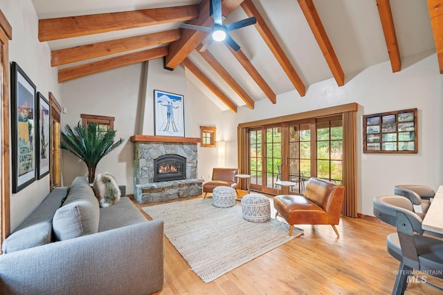 living room with high vaulted ceiling, a stone fireplace, ceiling fan, light wood-type flooring, and beam ceiling