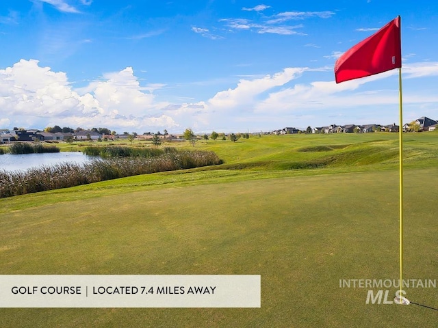 view of property's community featuring a residential view, a lawn, a water view, and view of golf course