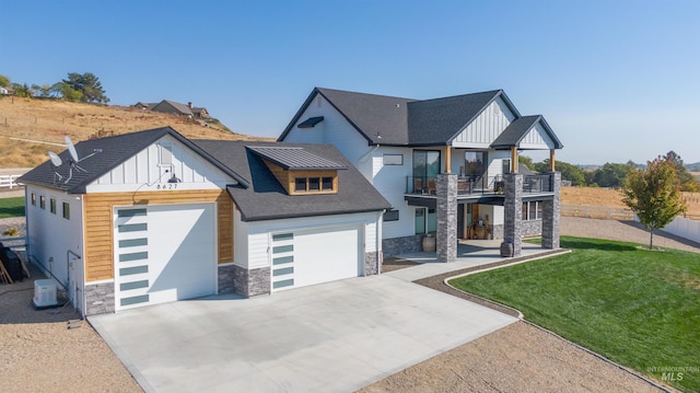 view of front facade with a garage, a balcony, stone siding, board and batten siding, and concrete driveway
