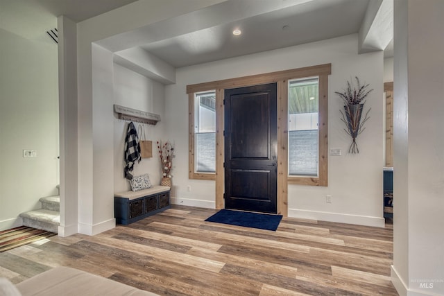 foyer with baseboards, stairway, and light wood-style floors