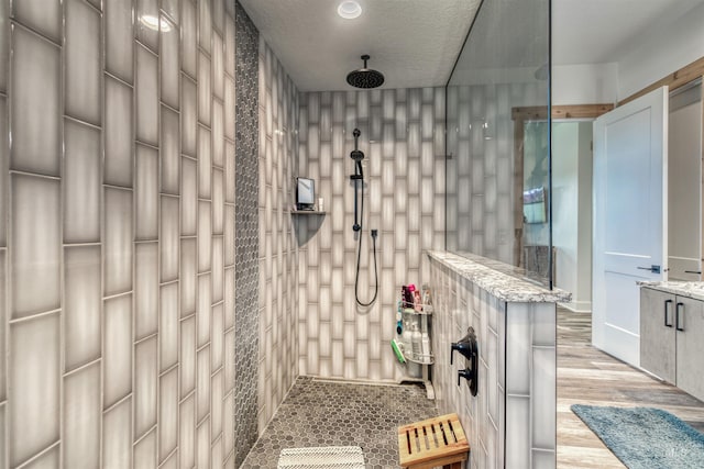 full bathroom featuring tiled shower and wood finished floors