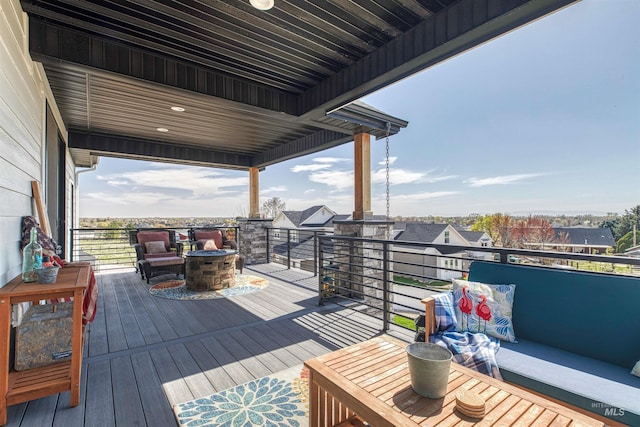 wooden terrace with an outdoor living space with a fire pit