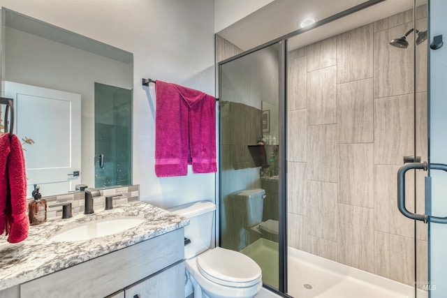bathroom featuring vanity, toilet, and a stall shower