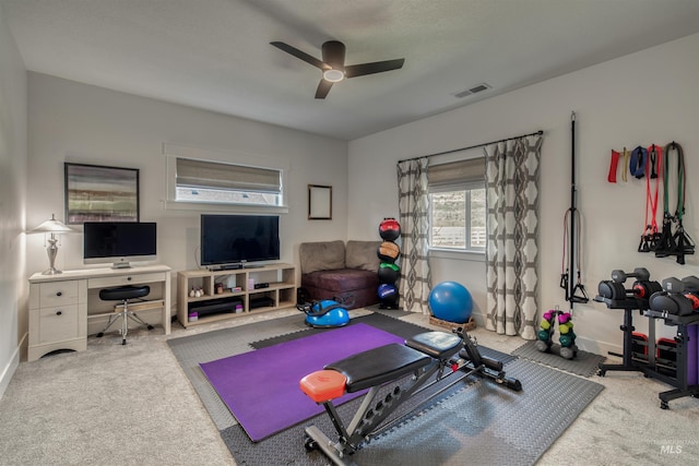 workout area featuring carpet floors, ceiling fan, visible vents, and baseboards