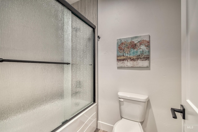 bathroom featuring shower / bath combination with glass door and toilet