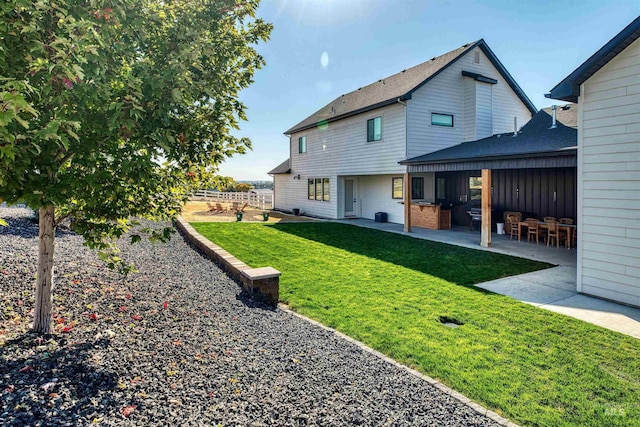 rear view of house with a patio area and a yard