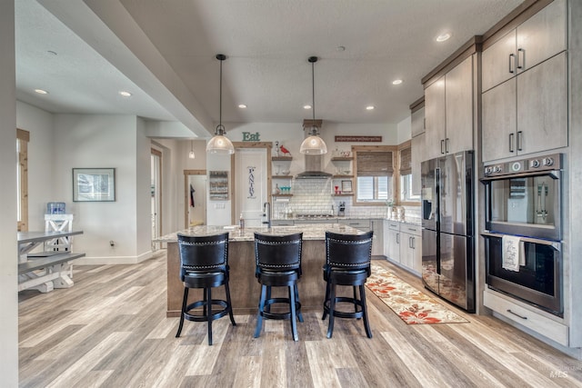 kitchen with recessed lighting, open shelves, appliances with stainless steel finishes, and light wood-type flooring