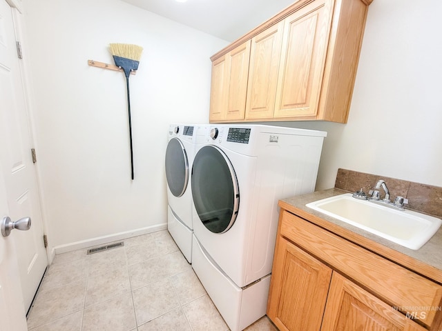 laundry area with light tile patterned floors, a sink, visible vents, washer and dryer, and cabinet space