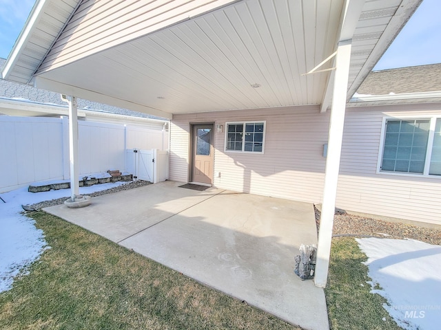 view of patio featuring a carport and fence