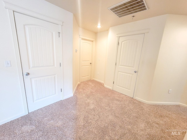 spare room with light carpet, visible vents, and baseboards