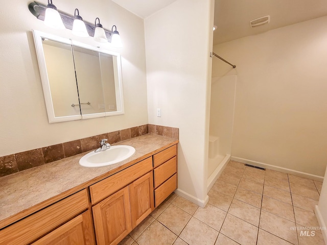 bathroom featuring a shower, tile patterned flooring, visible vents, and vanity