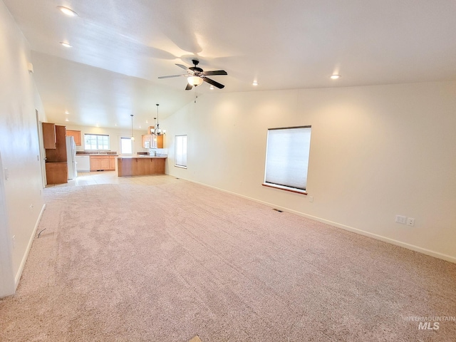 unfurnished living room featuring recessed lighting, light carpet, vaulted ceiling, baseboards, and ceiling fan with notable chandelier