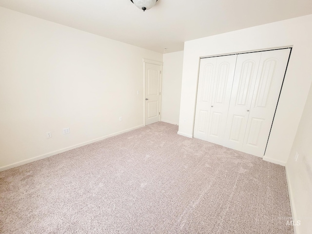 unfurnished bedroom featuring a closet, carpet flooring, and baseboards